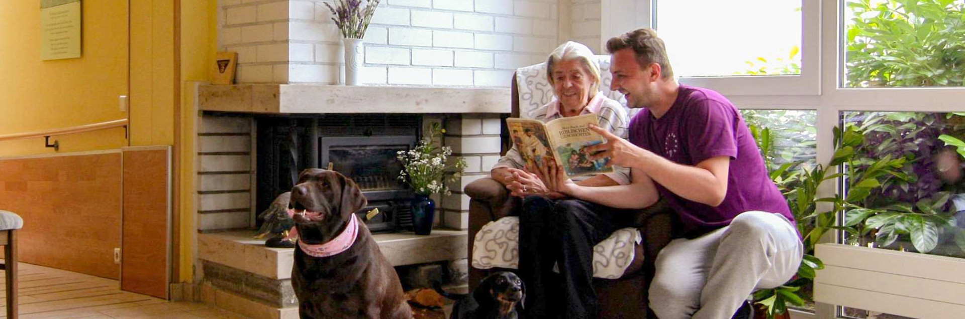 Pflegekraft kümmert sich in einer Wohngemeinschaft / Tagespflege um eine Seniorin